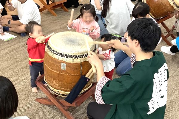 学生と一緒に和太鼓をたたく子どもたち